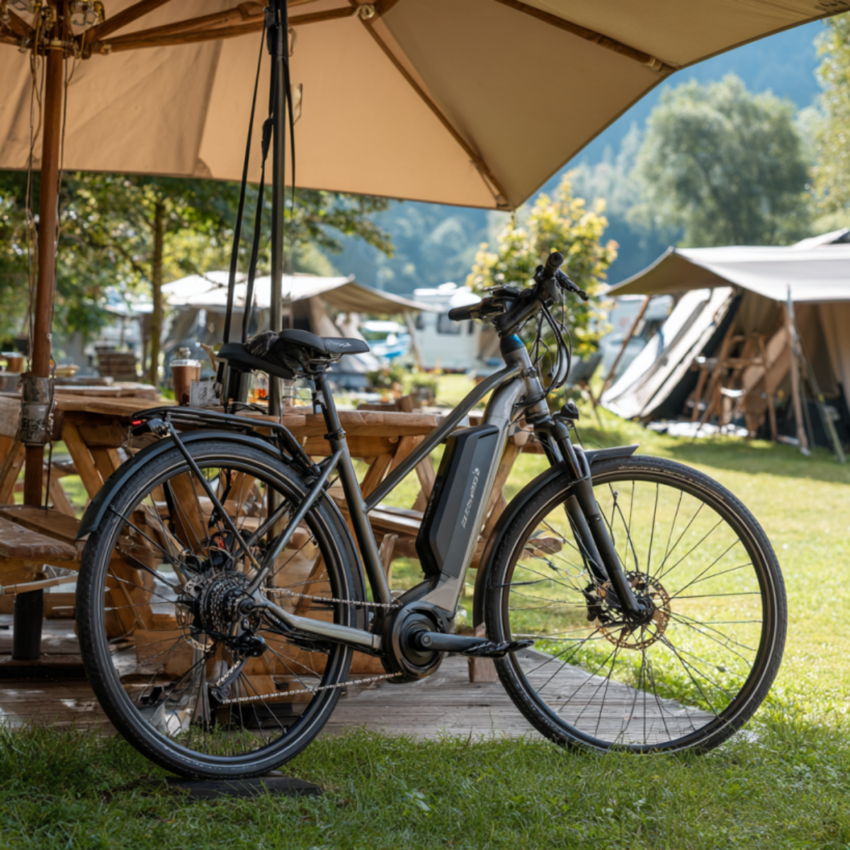 Fietsaccu die aan het opladen is in de schaduw op een camping