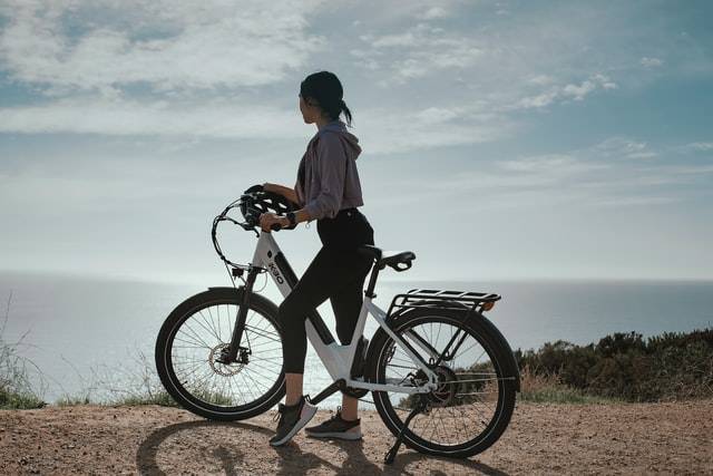 Elektrofahrrad mit der Sonne und dem Felsen eines Berges im Hintergrund